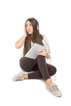 Cute teenage girl with headphones listening music on tablet
