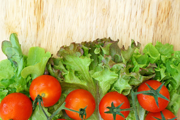 Tomatoes and lettuce on wooden background