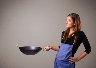 Young lady holding a frying pan