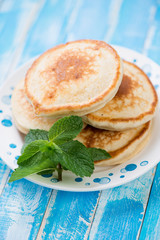 Freshly made fritters decorated with mint leaves, vertical shot