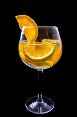 orange slices on a glass on wine with dark background