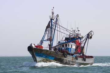 A fishing boat is at sea fishing.