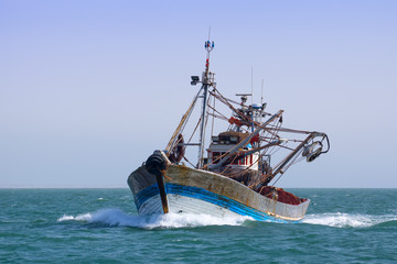 A fishing boat is at sea fishing.