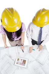 Architects discussing a set of blueprints