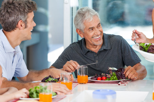 mature man with family dinner table