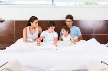 Fototapeta premium conflict family lying in a bedcouple with children