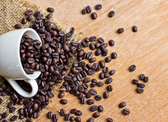 Coffee beans and cup on wood background