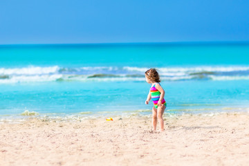 Fototapeta na wymiar Toddler girl playing on a beach