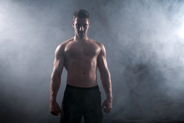 Fototapeta na wymiar Bodybuilder Mann Oerkörper nackt im Nebel Porträt