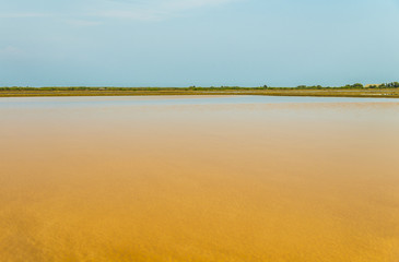 Orange salt pan with blue sky