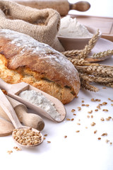 Healthy homemade bread with flour and wheat on white background