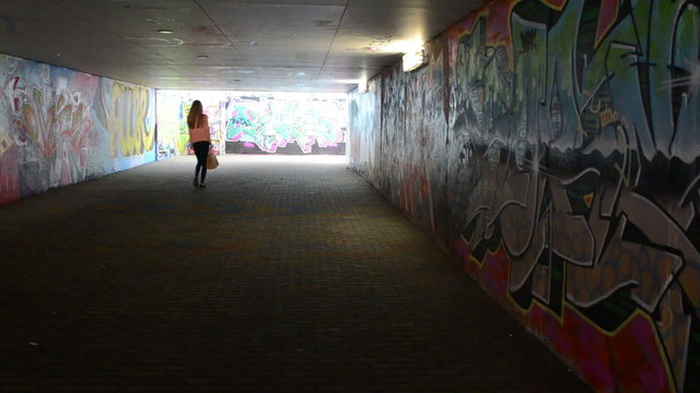 young woman walk city underground passage subway paint graffiti
