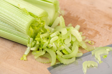 Fresh green celery cutting on wooden board.