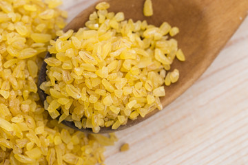 bulgur wheat in wooden spoon