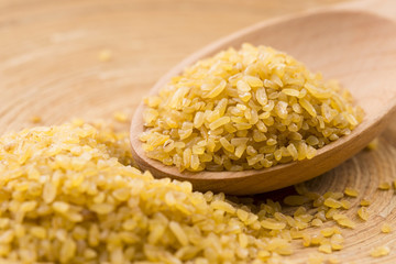 bulgur wheat in wooden spoon