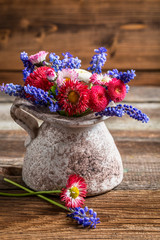 Spring flowers in a vase on wooden table