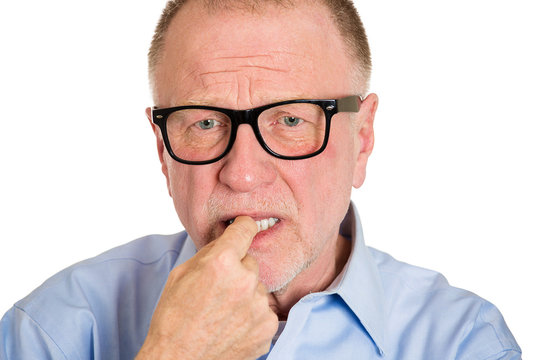Stress. Anxious senior man biting finger nails, white background
