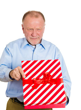 Bad gift ideas. Senior elderly man unhappy with present received