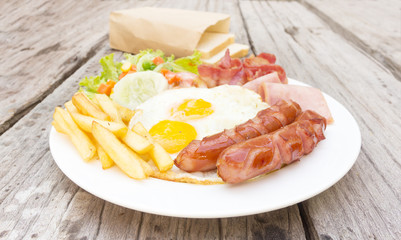 American  breakfast with fried eggs, bacon, sausages, toasts and