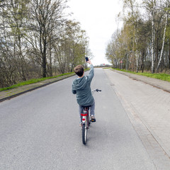 boy shoots a picture while riding bike