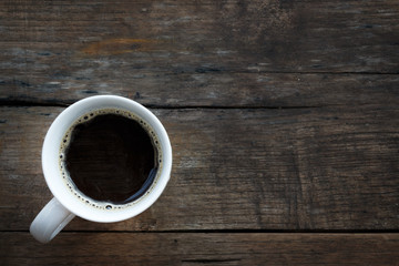 A white coffee cup on a wooden table background.