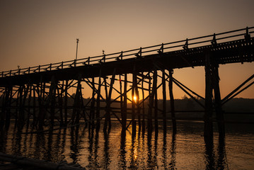 Obraz premium Sunset at the longest wooden bridge and floating Town in Sangkla