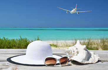 Sunglasses, hat and shell against ocean. Exuma, Bahamas