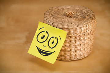 Post-it note with smiley face sticked on jewelry box