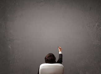 Businessman sitting in front of a wall with copy space