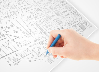 Human hand sketching ideas on a white paper