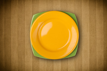 Colorful empty plate on grungy background table