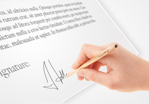Hand writing personal signature on a paper form
