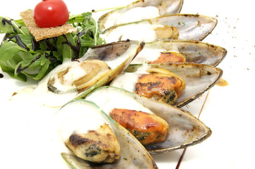 mussels with sauce and greens on a white background