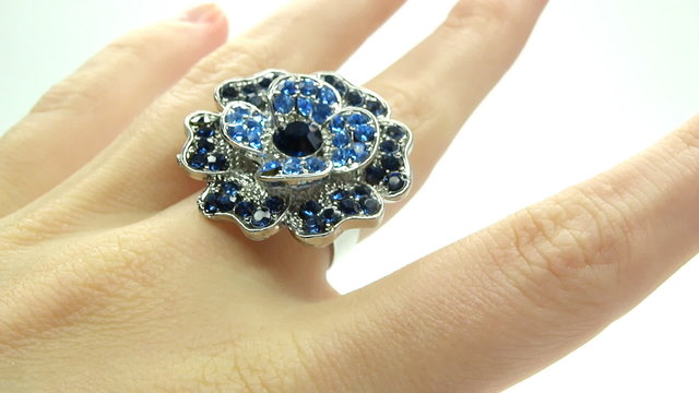 jewelery ring with blue sapphire crystals putting on the finger