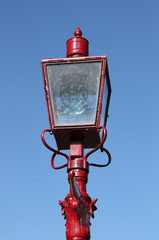 Old-fashioned red street lamp with Monifieth coat of arms