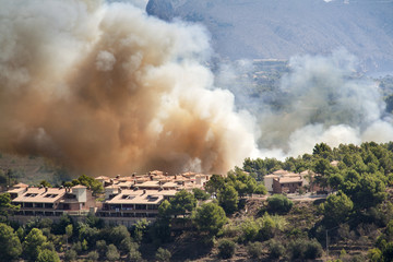 Fire burning mountain forest and village, danger for the houses