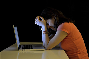 Young student woman and computer crying desperate suffering