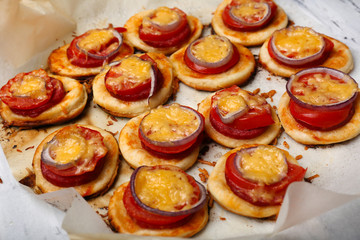 Small pizzas on baking paper close up