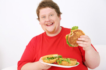 Fat man eating tasty sandwich on home interior background
