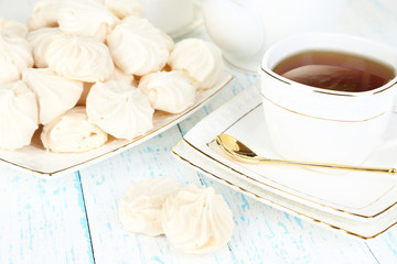 Fototapeta na wymiar Cup of tea with meringues on table close-up