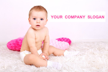 Cute little boy with pink pillows on carpet in room