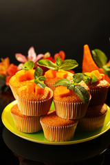 Tasty pumpkin muffins on dark background