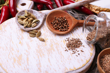 Different spices with blank cutting board, close up