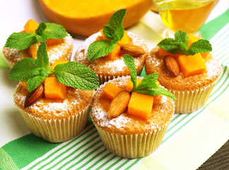 Tasty pumpkin muffins on wooden table