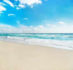 sea beach against wave foam and blue sunny sky - vacation concep