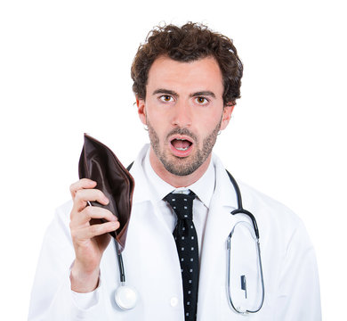 Closeup portrait Poor shocked doctor holding empty wallet