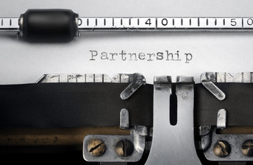 "Partnership" written on an old typewriter