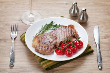 Sirloin steak with rosemary and cherry tomatoes on a plate