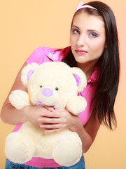 Childish woman infantile girl in pink hugging teddy bear toy