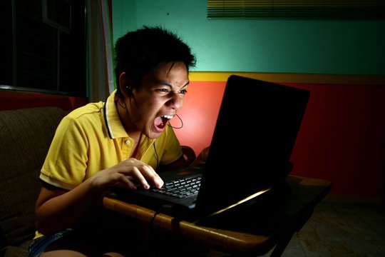 Asian Teen Playing or Working on a Laptop Computer